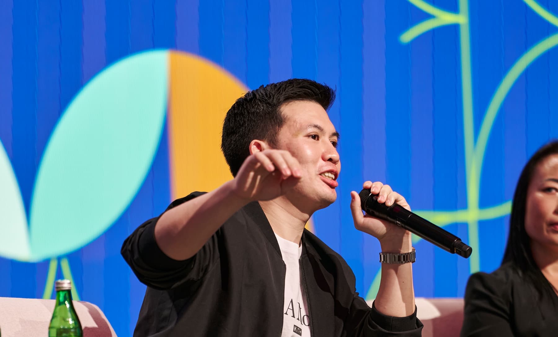 Thomas Ma on stage mid-answer, microphone in hand